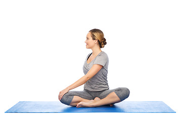 Image showing woman making yoga in twist pose on mat