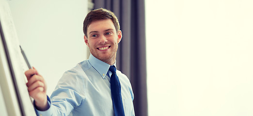 Image showing smiling businessman on presentation in office