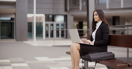 Image showing Woman sitting with laptop on bench outdoors