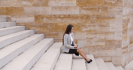 Image showing Low angle view of woman using laptop outdoors