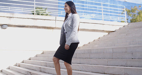 Image showing Serious woman walking up staircase