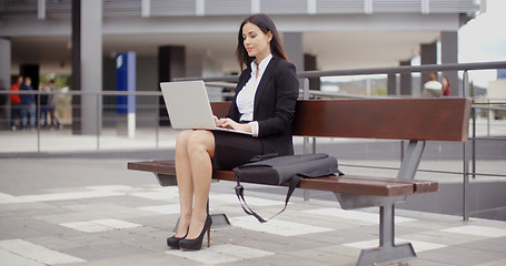 Image showing Business woman alone with laptop on bench