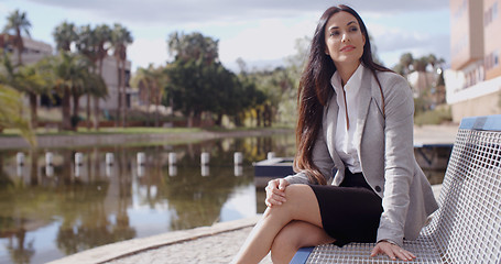 Image showing Business woman sitting on bench looking away