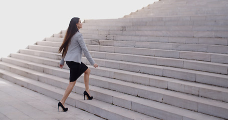 Image showing Serious woman walking up staircase