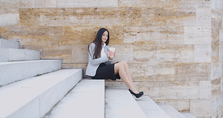 Image showing Business woman looking at coffee cup