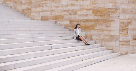 Image showing Woman using laptop in the distance