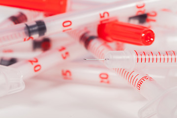 Image showing Pile of Empty Syringes with Red Safety Caps