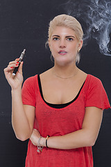 Image showing Stylish blond woman smoking an e-cigarette