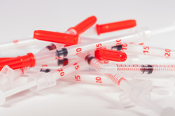 Image showing Pile of Empty Syringes with Red Safety Caps