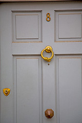 Image showing handle in london antique brown door  rusty  brass nail and light