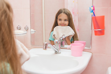 Image showing Happy girl wipes her wet face towel in the bathroom