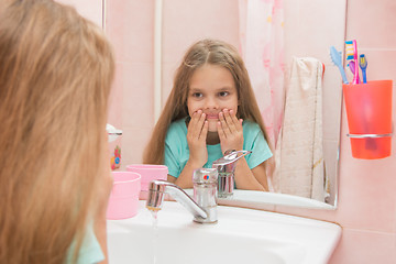 Image showing Six year old girl washes her mouth after brushing your teeth in the bathroom