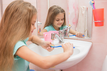 Image showing Girl rinse the toothbrush under running tap water