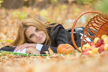 Image showing Young girl lies on the on the foliage in the autumn forest