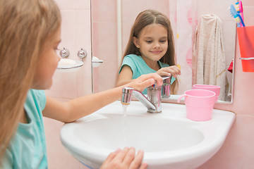 Image showing Girl closes after washing the mixer tap in the bathroom