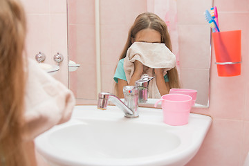 Image showing Baby wipes face with a towel in the bathroom