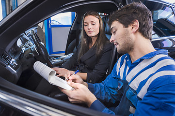 Image showing Car expert shows reparations to customer