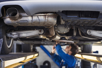 Image showing Exhaust of a car with mechanic underneath