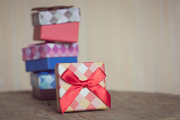 Image showing Gift box with red bow on wood background