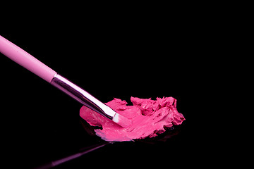 Image showing lipstick with a brush make-up on black 