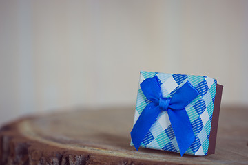 Image showing Gift box with red bow on wood background