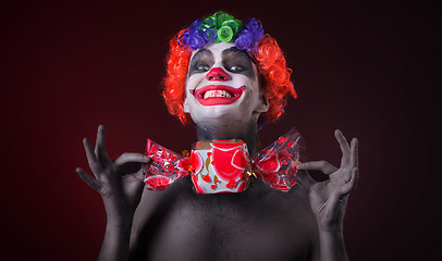 Image showing scary clown with spooky makeup and more candy 