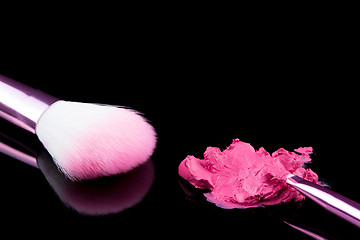 Image showing lipstick with a brush make-up on black 