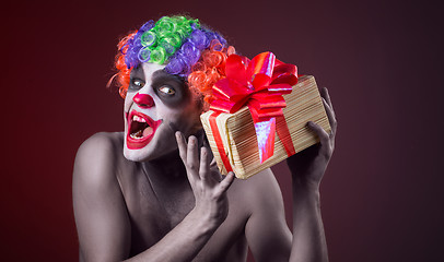 Image showing scary clown makeup and with a terrible gift