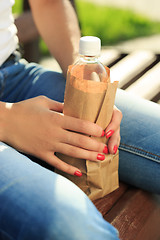 Image showing girl holding a plastic bottle in a paper bag