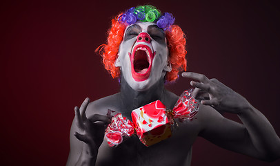 Image showing scary clown with spooky makeup and more candy 