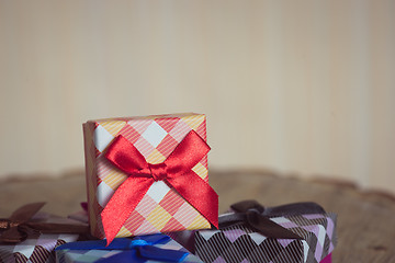 Image showing Gift box with red bow on wood background