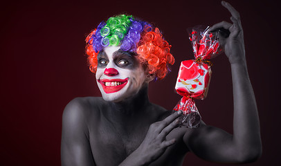 Image showing scary clown with spooky makeup and more candy 