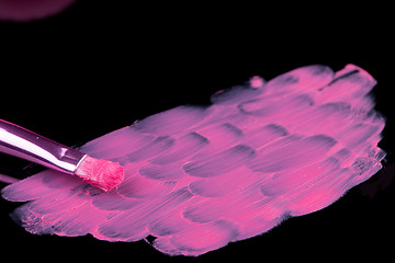 Image showing lipstick with a brush make-up on black 