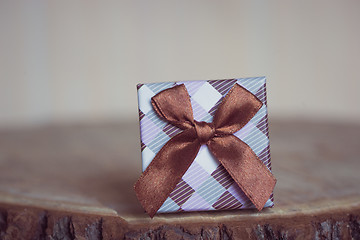 Image showing Gift box with red bow on wood background