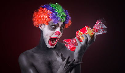 Image showing scary clown with spooky makeup and more candy 