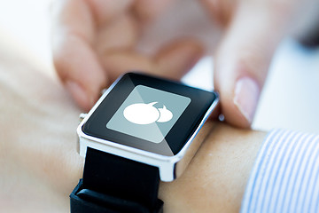 Image showing close up of hands with message icon on smartwatch