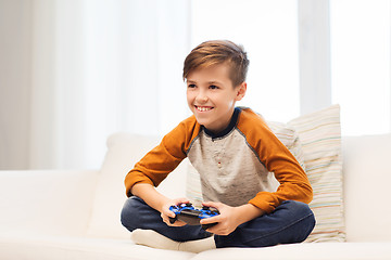 Image showing happy boy with joystick playing video game at home