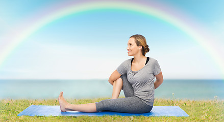 Image showing woman making yoga in twist pose on mat