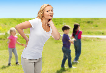 Image showing woman suffering from backache over group of kids
