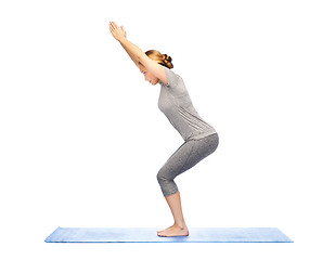 Image showing woman making yoga in chair pose on mat