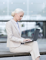 Image showing businesswoman working with laptop outdoors