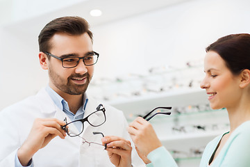 Image showing woman and optician showing glasses at optics store