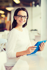 Image showing smiling woman with tablet pc at cafe