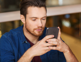 Image showing man with smartphone reading message at restaurant