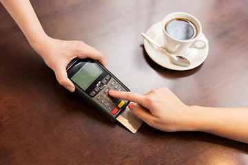 Image showing close up of hands with credit card reader at cafe