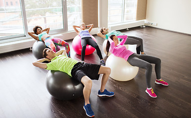 Image showing happy people flexing abdominal muscles on fitball