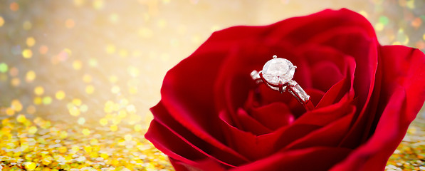 Image showing close up of diamond engagement ring in rose flower