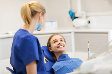 Image showing happy female dentist with patient girl at clinic