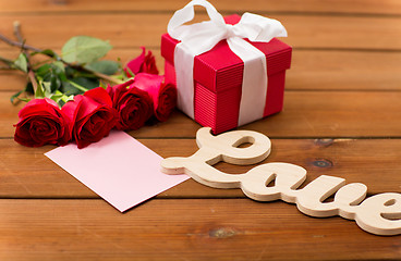 Image showing close up of gift box, red roses and greeting card