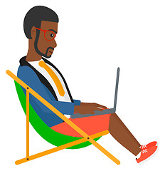 Image showing Businessman sitting in chaise lounge with laptop.